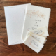 Hochzeitseinladung mit bronzefarbenem Olivenzweig auf handgeschöpftem Papier
